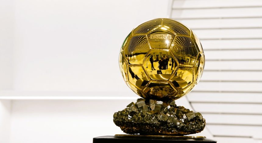 Golden football trophy silhouette surrounded by statistics and voting sheets, with the text BALLON D’OR RECORDS